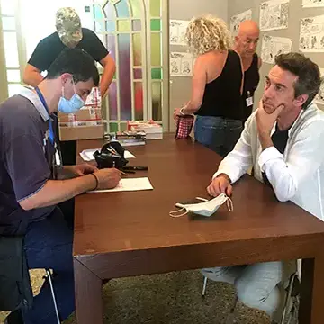 Rimini Comix, Palazzina Roma, Marco Martellini nell'atto di realizzare una caricatura al noto attore Alessio Boni – Rimini 2021