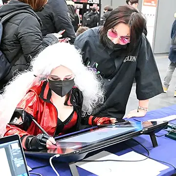 Torino Comics, stand della scuola – due ragazzi disegnano con le attrezzature Wacom della scuola – Torino 2021